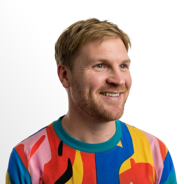 man with colorful shirt looking into the distant